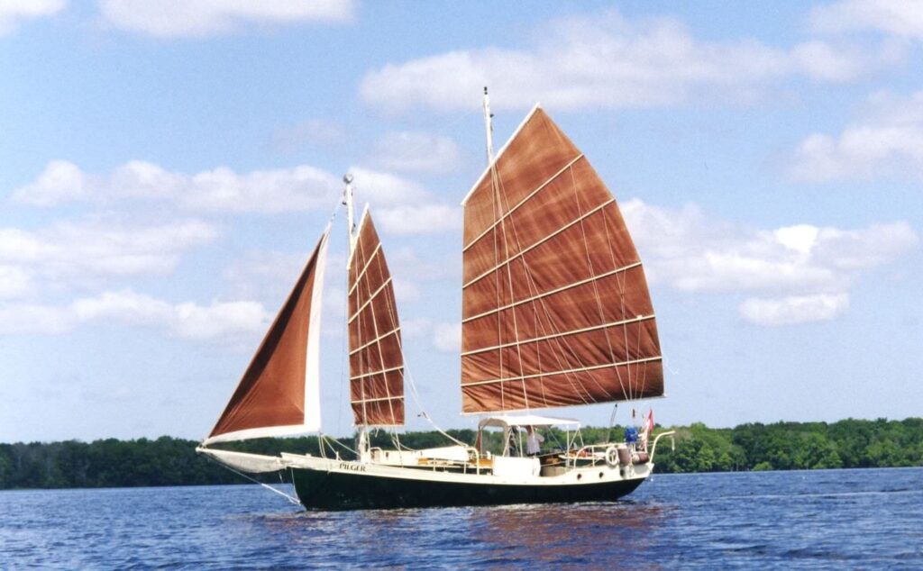 junk sailboat example on water with two sails open on fron mast and one large sail open main mast